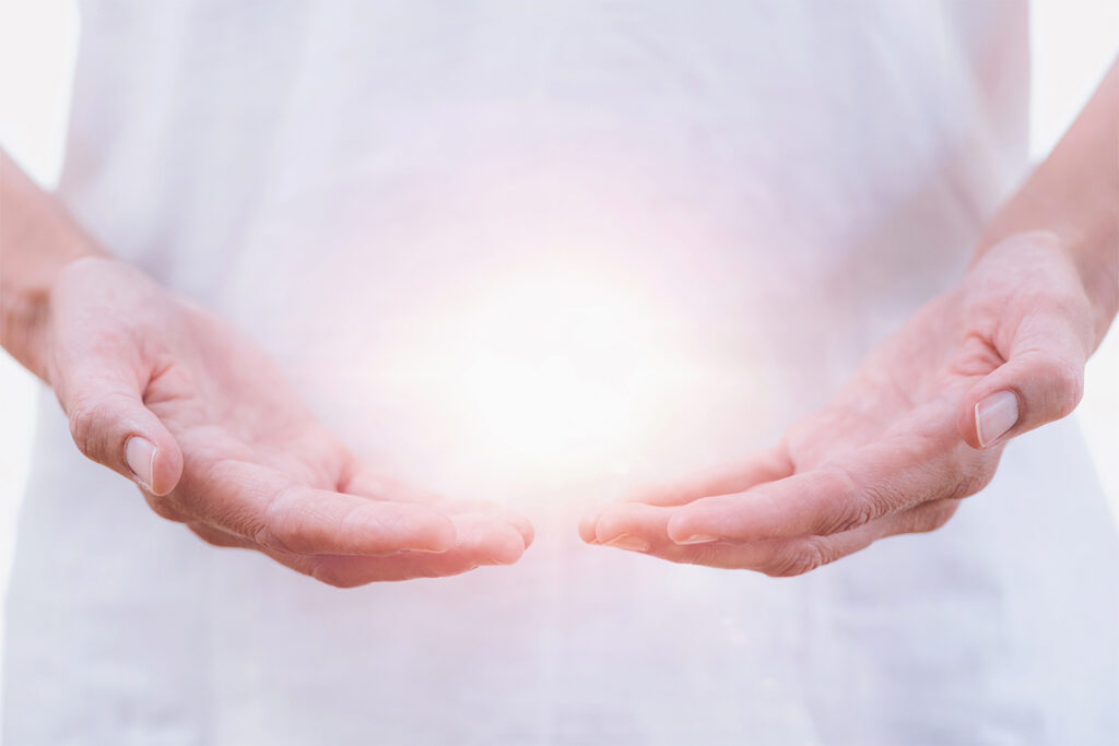 mano iluminadas ebocando energía en proceso de sanación holística