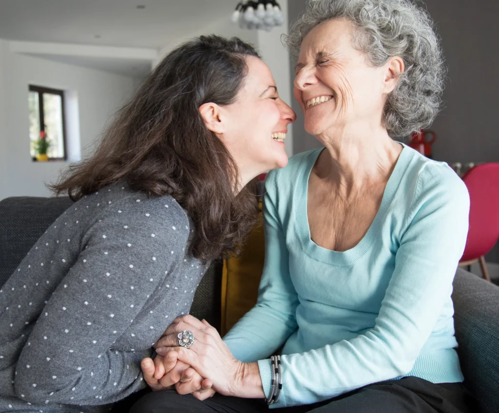 Madre e hija sonriendo juntas en un momento de conexión emocional, representando una sesión holística familiar para sanar vínculos desde el alma