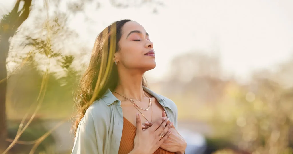Mujer en conexión espiritual durante sesión holística individual al aire libre